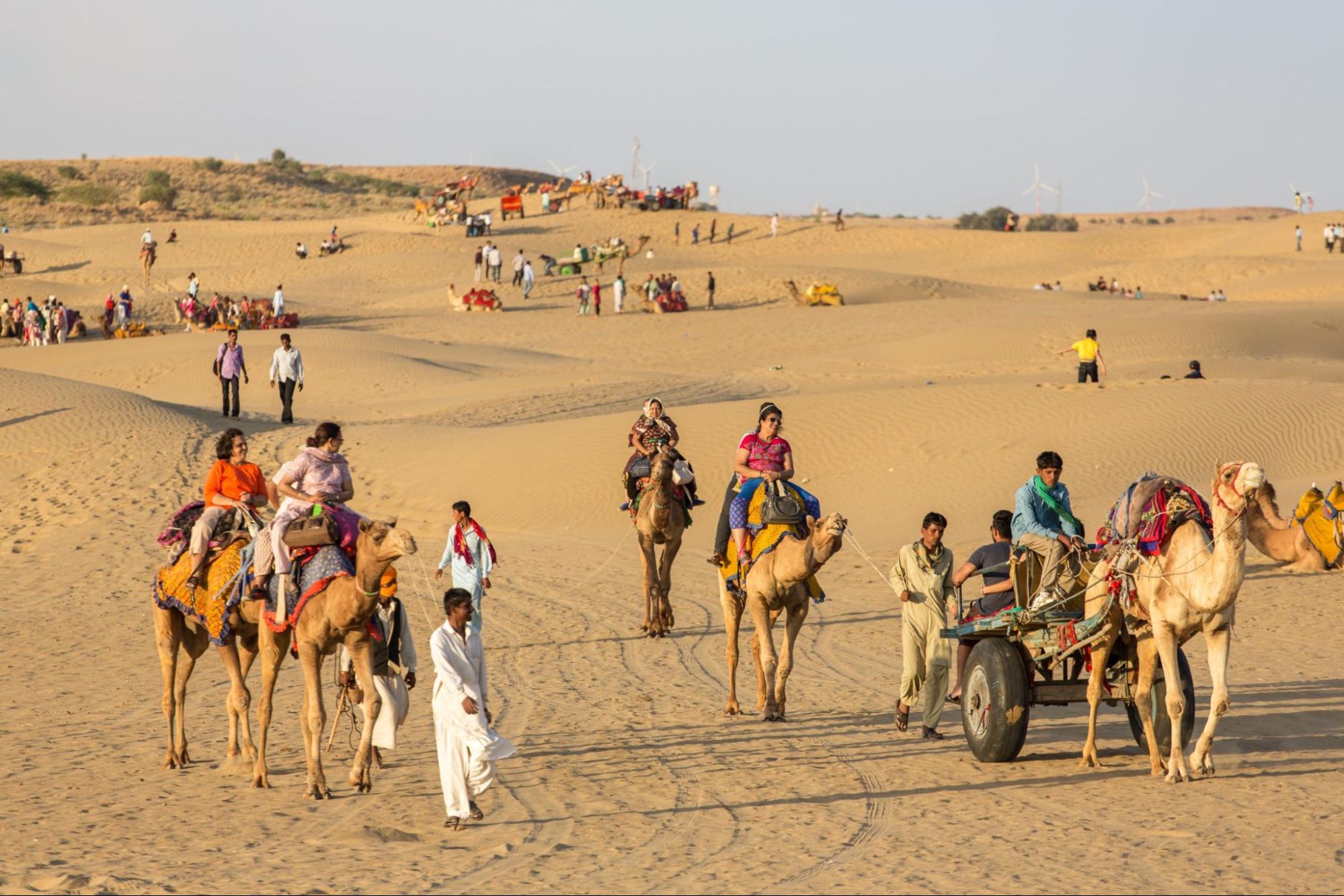 tourists riding camels in Thar desert, Rajasthan, India